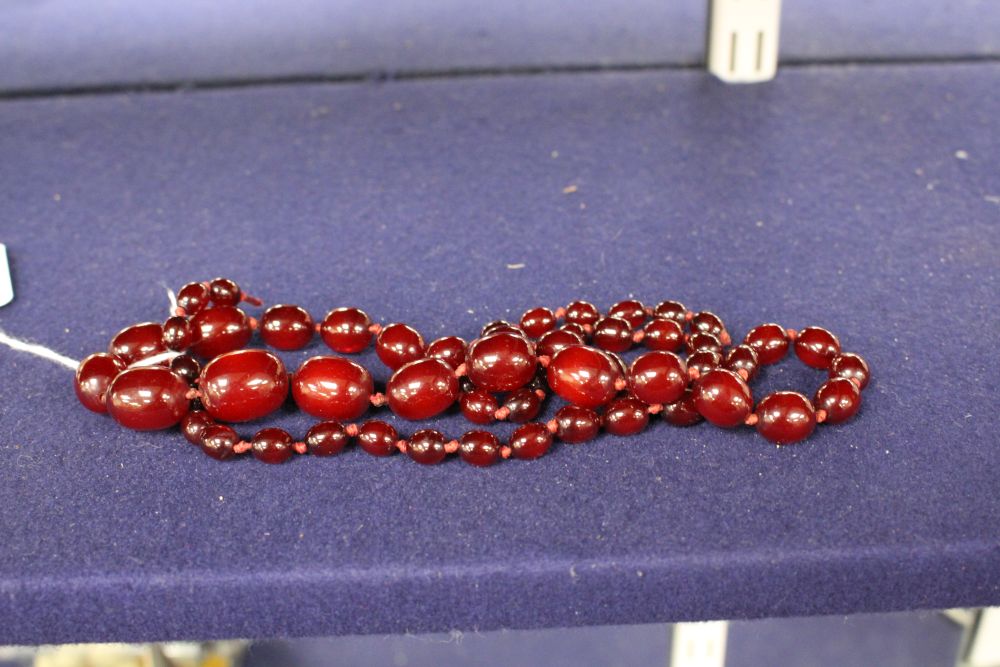 A single strand graduated simulated cherry amber bead necklace, gross weight 55 grams and assorted costume jewellery.